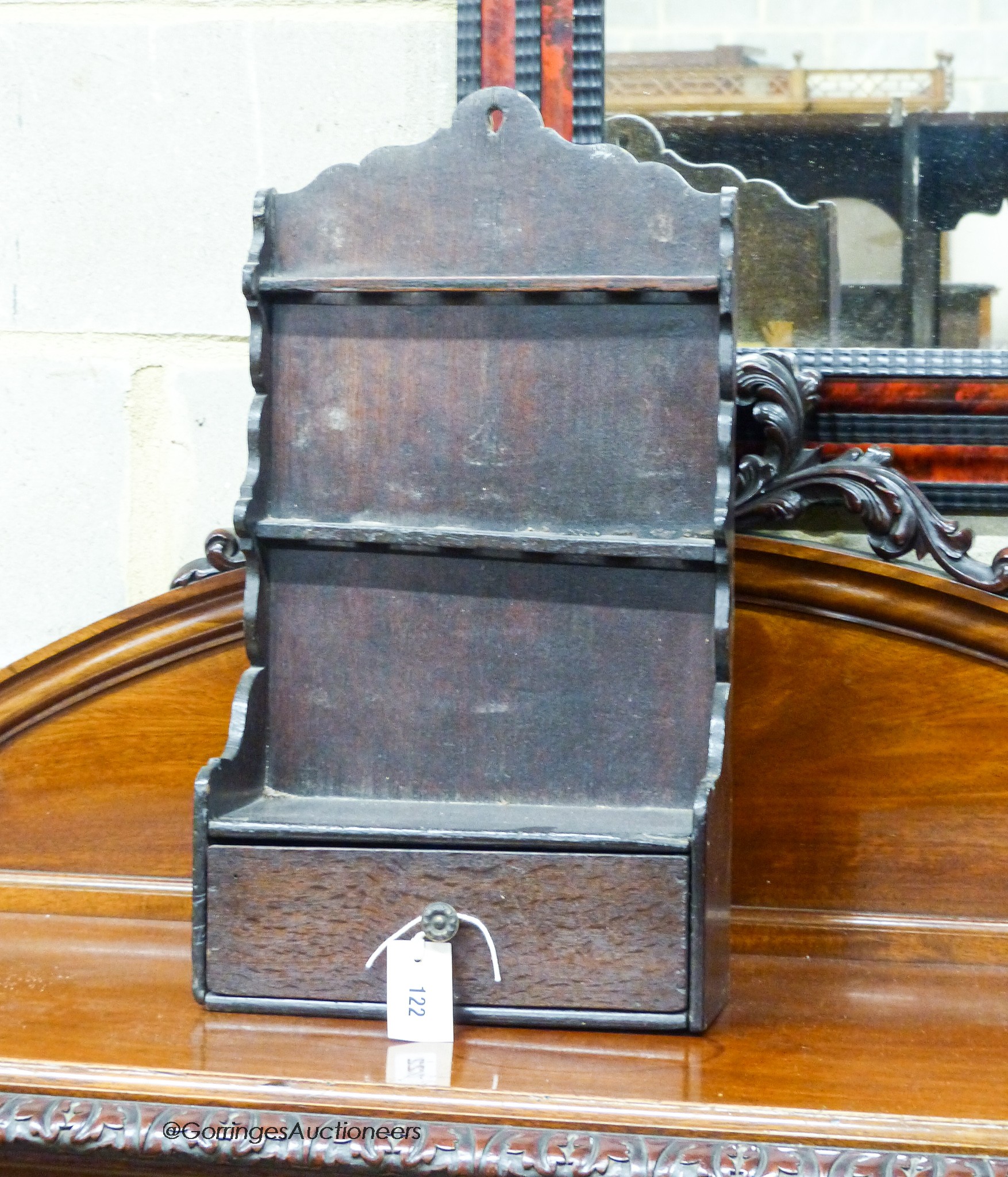 An 18th century oak spoon rack, of shaped outline with drawer below, width 29cm, depth 13cm, height 54cm